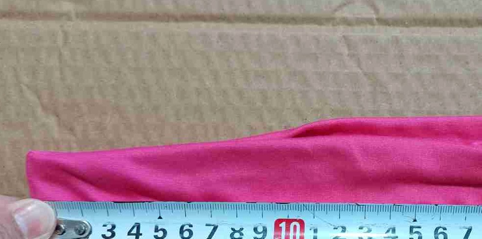 Anonymous close-up of an inspector measuring a finished textile item